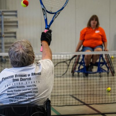 Man and woman in wheelchairs playing tennis